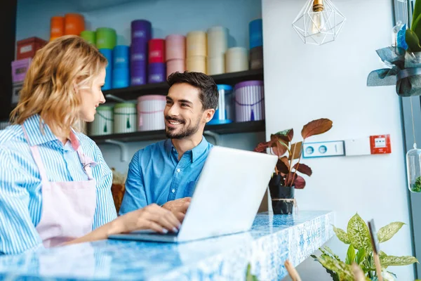 Florista e cliente com laptop — Fotografia de Stock