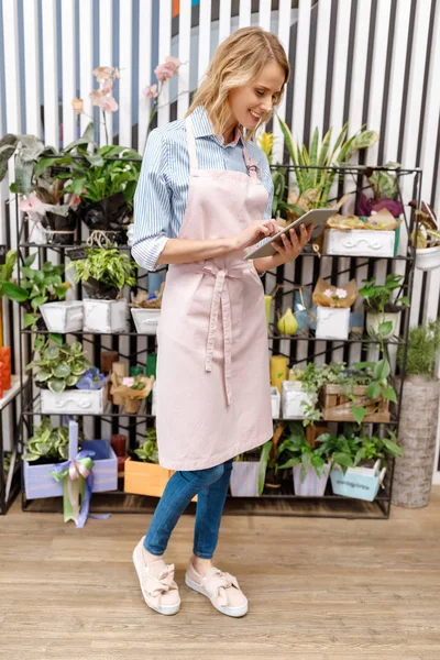 Florist with digital tablet in flower shop — Stock Photo