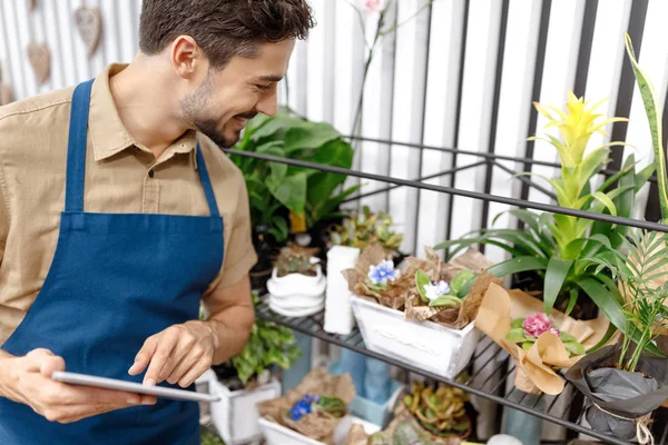 Fleuriste masculin avec tablette numérique — Photo de stock