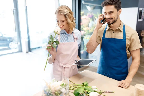 Floristas que trabajan con dispositivos digitales - foto de stock