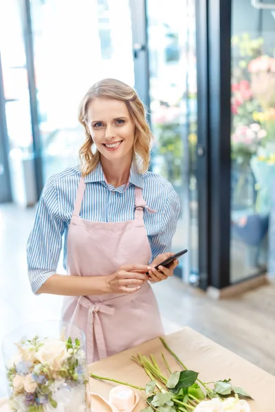 Fiorista utilizzando smartphone — Foto stock