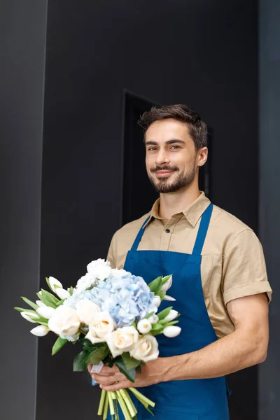 Handsome florist with flowers — Stock Photo