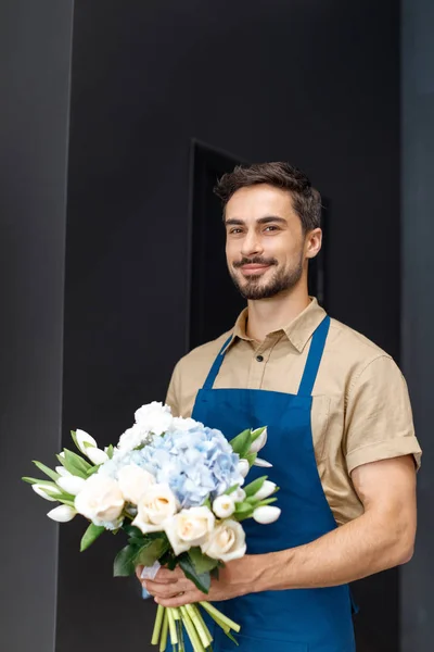 Schöner Blumenhändler mit Blumen — Stockfoto