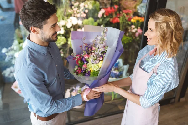 Florista y comprador con ramo - foto de stock