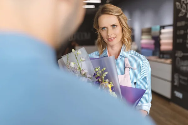 Florista e comprador com buquê — Fotografia de Stock