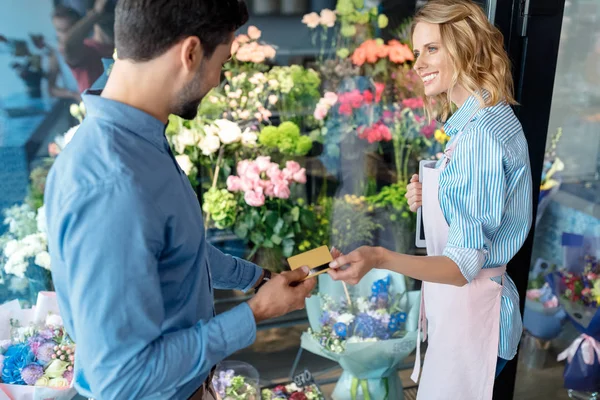 Florista y cliente con tarjeta de crédito - foto de stock