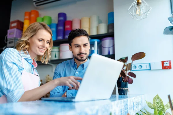 Florista e cliente com laptop — Fotografia de Stock