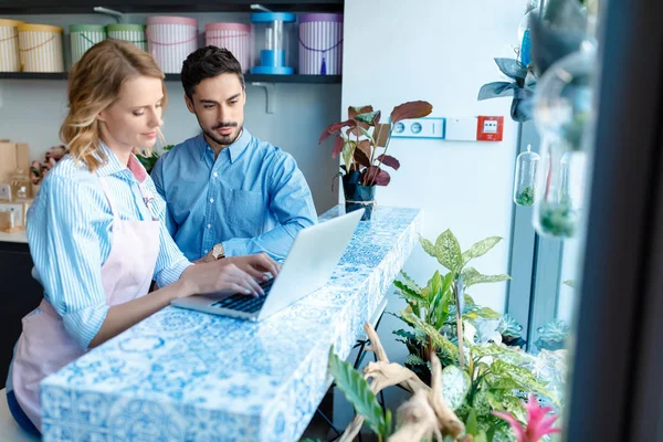 Florist and client with laptop — Stock Photo