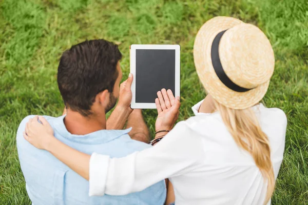 Couple with tablet on green lawn — Stock Photo