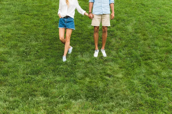 Couple marche sur la pelouse verte — Photo de stock