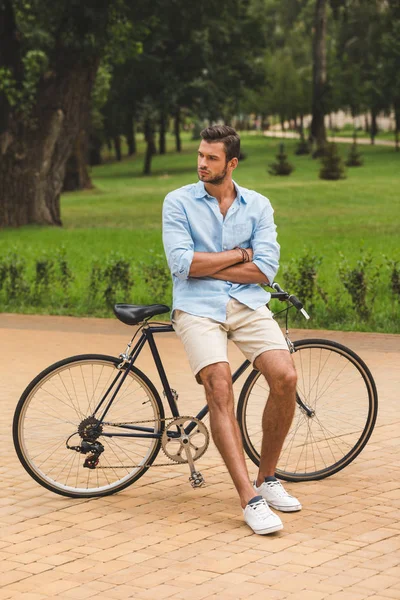 Людина з велосипедом в парку — стокове фото
