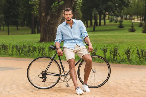 Людина з велосипедом в парку — стокове фото