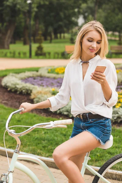 Woman with smartphone in park — Stock Photo