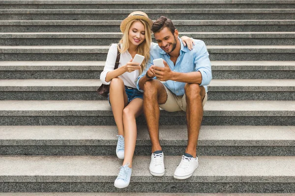 Couple avec smartphones dans la rue — Photo de stock