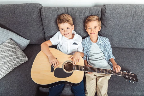 Маленькие братья с гитарой — стоковое фото