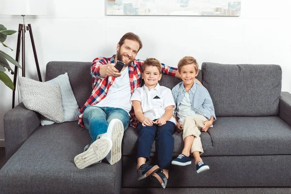 Pai com filhos assistindo tv — Fotografia de Stock