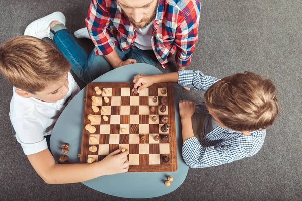 Padre con figli giocare a scacchi — Foto stock
