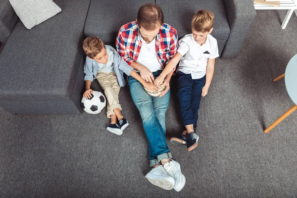 Family watching soccer match at home — Stock Photo