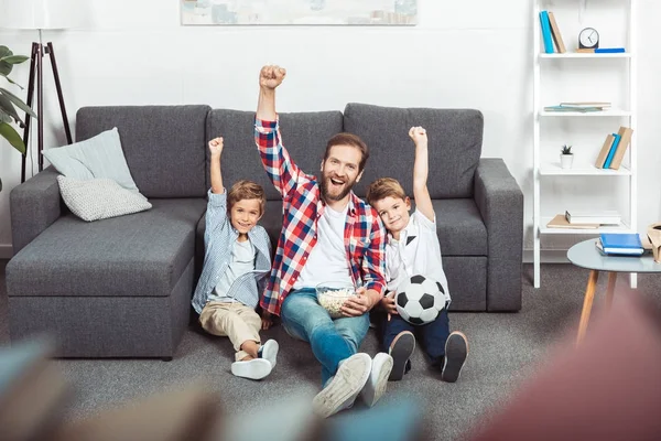 Family watching soccer match at home — Stock Photo