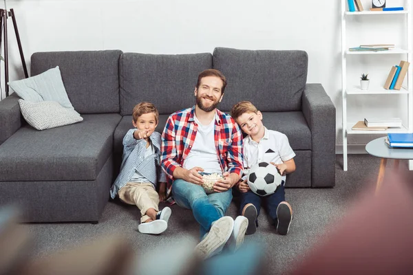 Family watching soccer match at home — Stock Photo