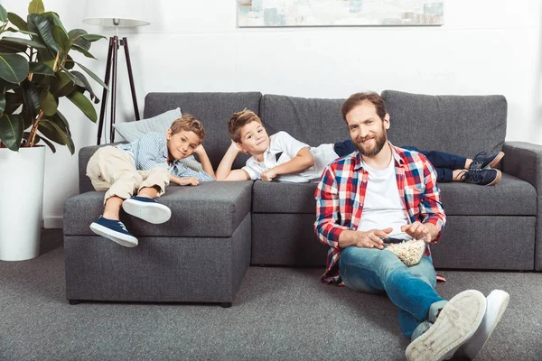 Family eating popcorn at home — Stock Photo