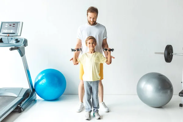 Padre e hijo entrenando con pesas - foto de stock