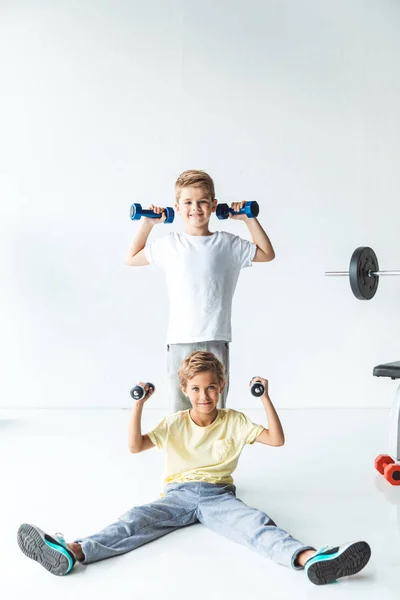 Niños haciendo ejercicio con pesas - foto de stock