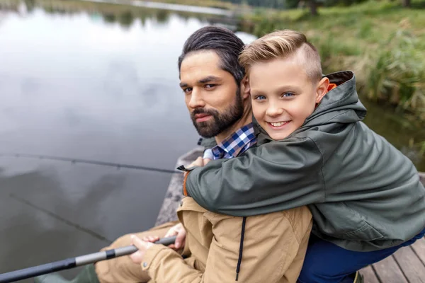Padre e hijo pescando con cañas - foto de stock