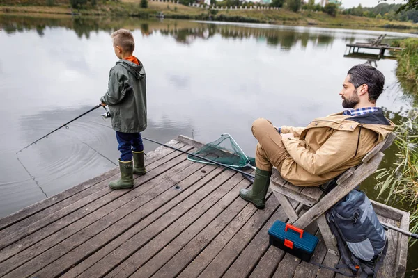 Pai e filho pesca com hastes — Fotografia de Stock