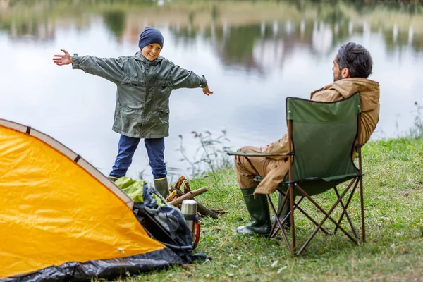 Padre e hijo en camping en el lago - foto de stock