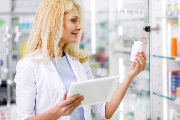 Pharmacien avec comprimé numérique et médicament — Photo de stock