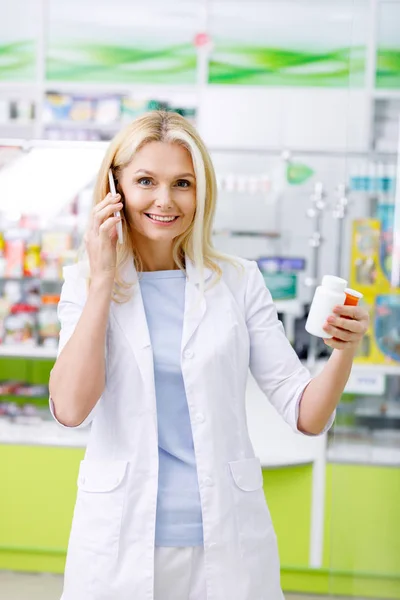 Pharmacist talking on smartphone — Stock Photo