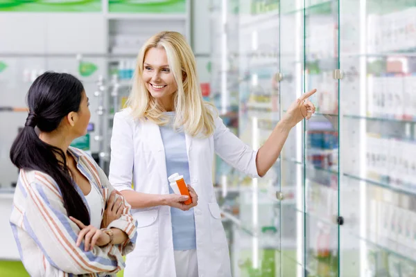 Pharmacist consulting customer in drugstore — Stock Photo