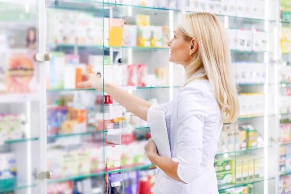 Farmacéutico con tableta digital en farmacia - foto de stock