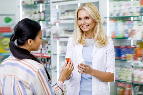 Фармацевт консультирует клиента в аптеке — стоковое фото