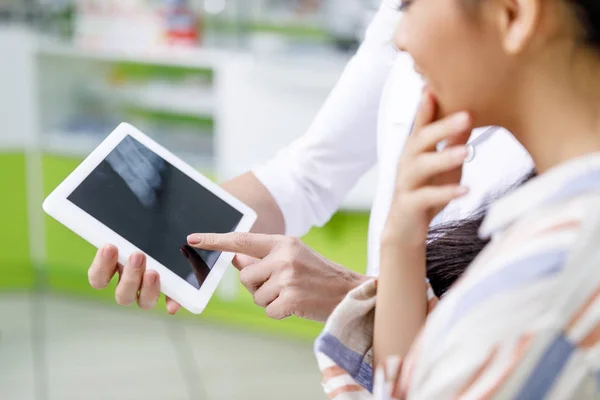 Pharmacist with digital tablet and customer — Stock Photo