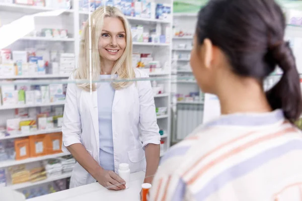 Farmacéutico y cliente en farmacia - foto de stock