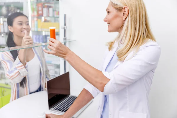 Фармацевт і клієнт в аптеці — стокове фото