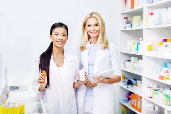 Farmacéuticos con tableta digital y medicamentos - foto de stock
