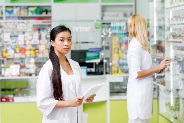 Pharmacien asiatique avec comprimé numérique — Photo de stock