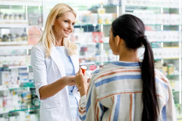 Pharmacien donnant des médicaments au client — Photo de stock