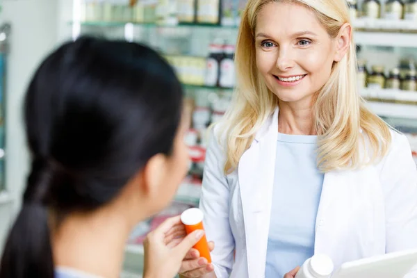 Farmacêutico dando medicação ao cliente — Fotografia de Stock