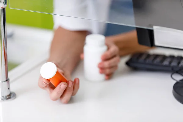 Farmacista che tiene contenitori con farmaci — Foto stock