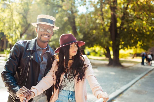 Boyfriend helping girlfriend riding bike — Stock Photo