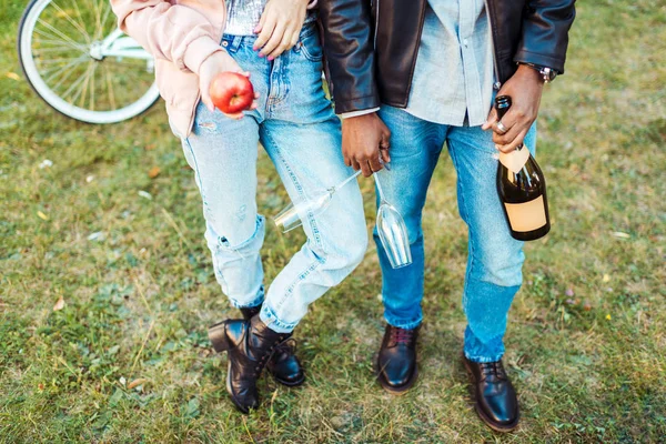 Couple debout avec pomme, verres et champagne — Photo de stock