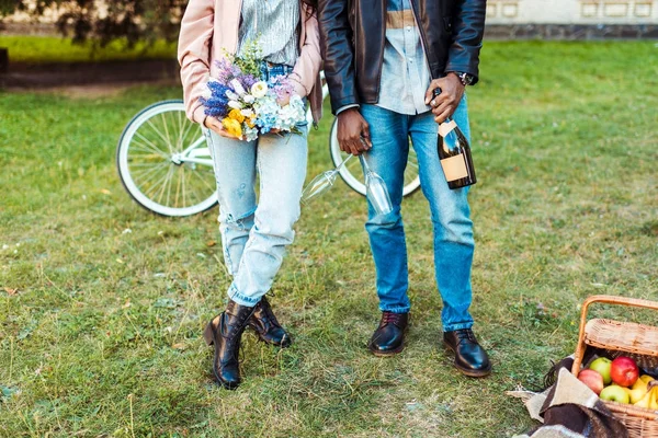 Paar steht mit Blumen und Champagner — Stockfoto