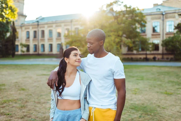 Pareja interracial de pie en ropa deportiva - foto de stock