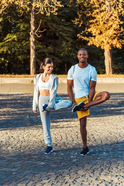Couple stretching on road — Stock Photo