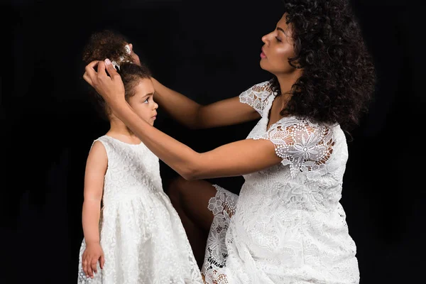 Mother fixing bow to daughter — Stock Photo