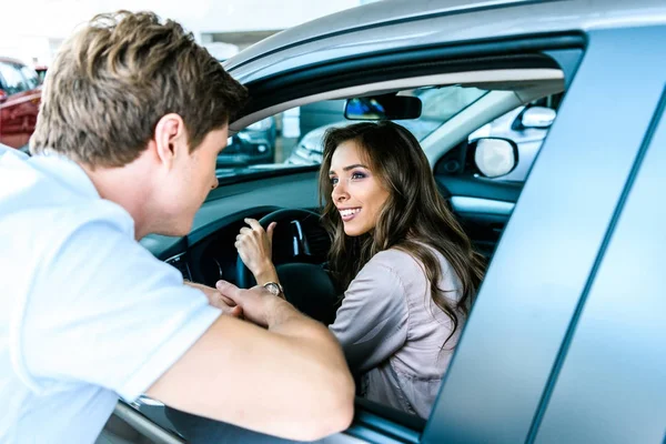 Mann spricht Frau an, die im Auto sitzt — Stockfoto